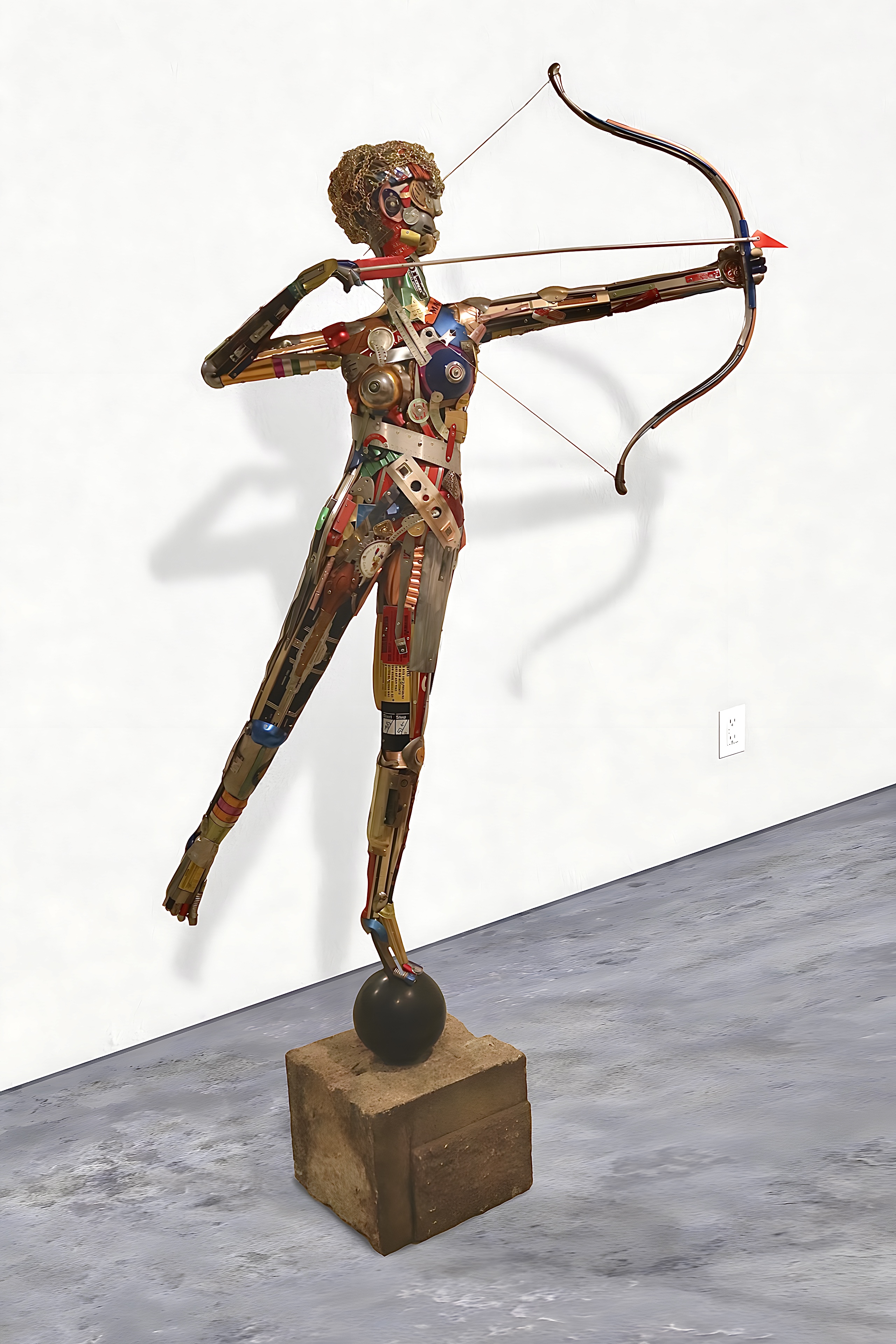 A life-size archer figure assembled from hundreds of found metal and plastic objects by Leo Sewell