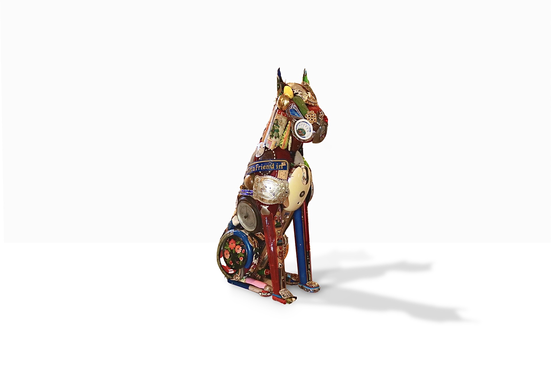 A muscular boxer dog sculpture assembled from hundreds of found metal, wood, and plastic objects by Leo Sewell